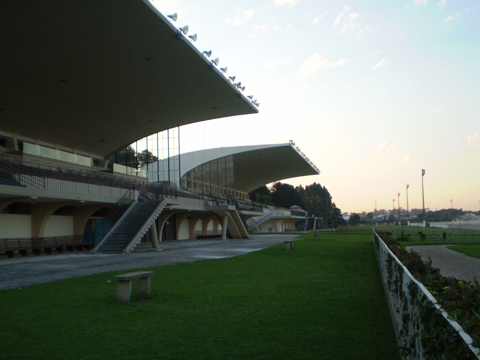 Arquibancadas modernistas do Hipódromo do Tarumã, com as marquises de concreto em balanço, ao entardecer